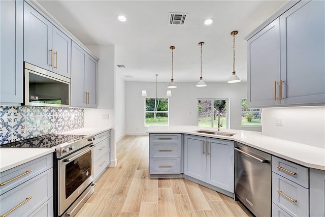 kitchen featuring gray cabinetry, visible vents, appliances with stainless steel finishes, and a sink