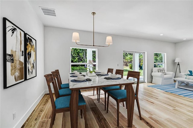 dining room featuring visible vents, baseboards, light wood-type flooring, recessed lighting, and a notable chandelier