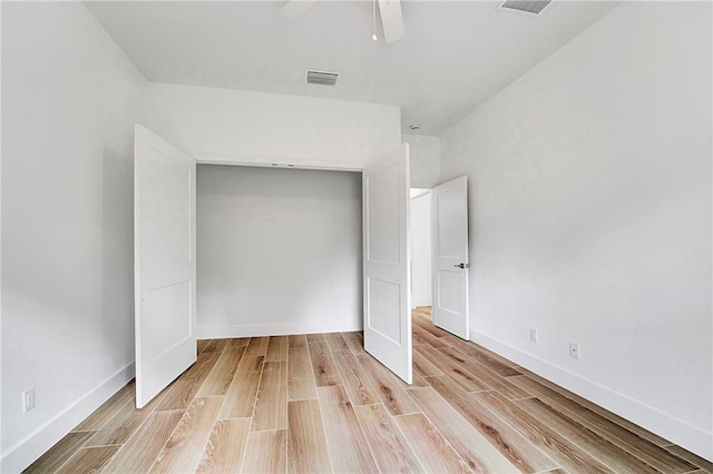 unfurnished bedroom featuring a closet, visible vents, light wood-type flooring, and baseboards