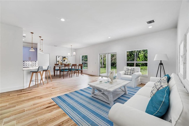 living room featuring recessed lighting, visible vents, light wood-style flooring, and baseboards