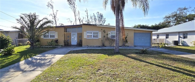 view of front facade featuring a garage, a front yard, and central AC