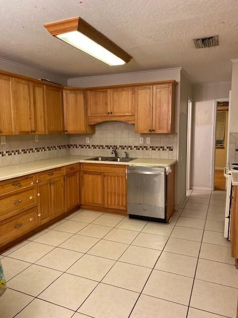 kitchen with sink, range, a textured ceiling, light tile patterned floors, and dishwasher