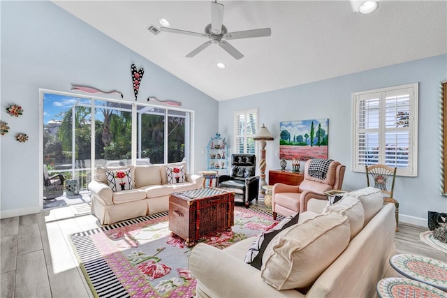 living room with ceiling fan, plenty of natural light, light hardwood / wood-style floors, and vaulted ceiling