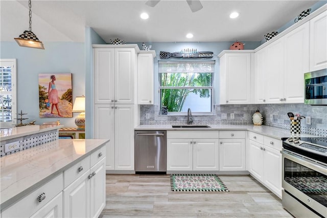 kitchen featuring appliances with stainless steel finishes, white cabinetry, and sink