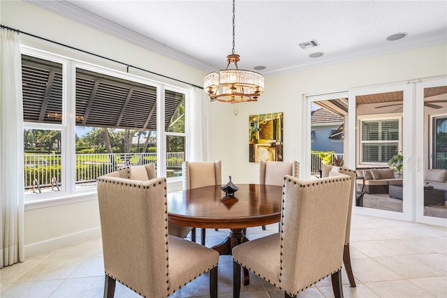 dining area with light tile patterned floors, baseboards, visible vents, and crown molding