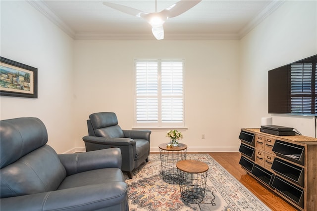 living room with ornamental molding, wood finished floors, and baseboards