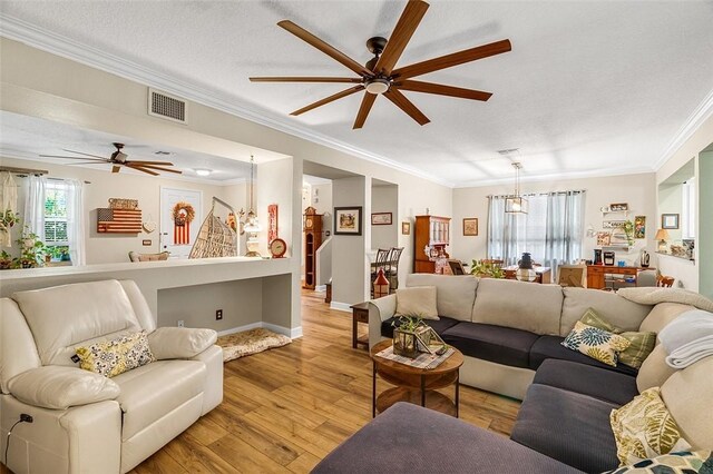 7720 15th Ln, Vero Beach, FL 32966 - living room featuring a ceiling fan, crown molding, light wood-style floors, baseboards, and visible vents