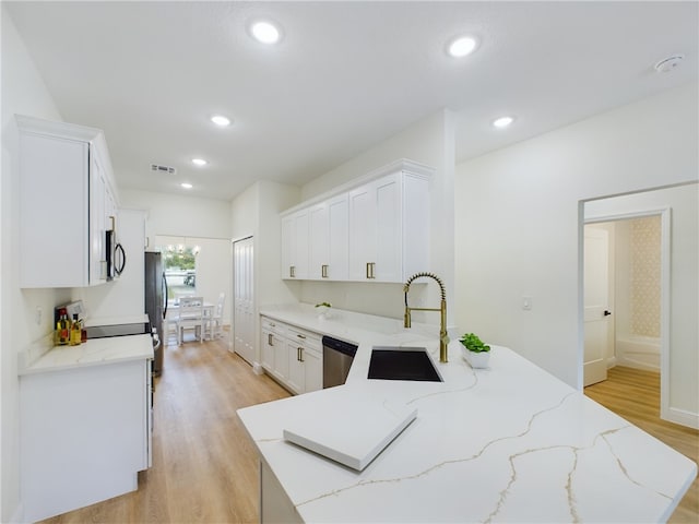 kitchen with light stone countertops, sink, white cabinets, and appliances with stainless steel finishes