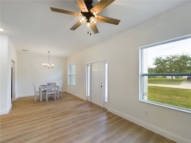 foyer with light hardwood / wood-style flooring and ceiling fan with notable chandelier