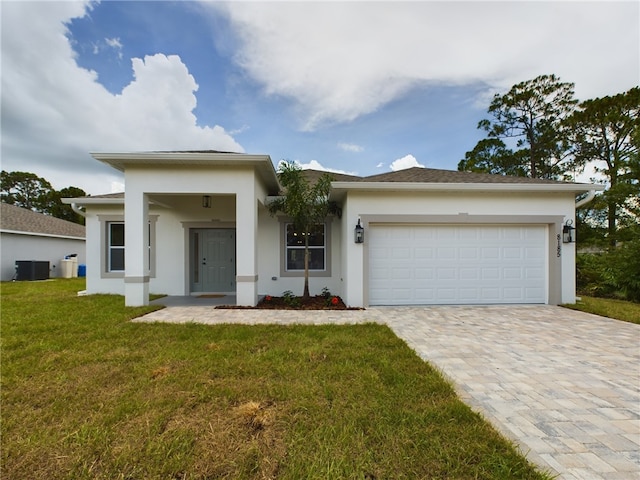 view of front of house featuring central AC unit, a front yard, and a garage