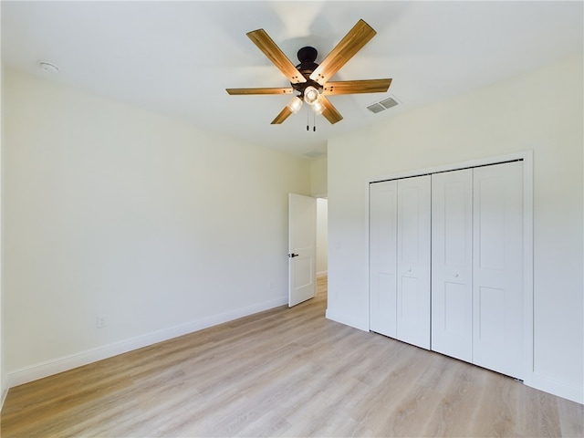 unfurnished bedroom featuring a closet, light hardwood / wood-style flooring, and ceiling fan