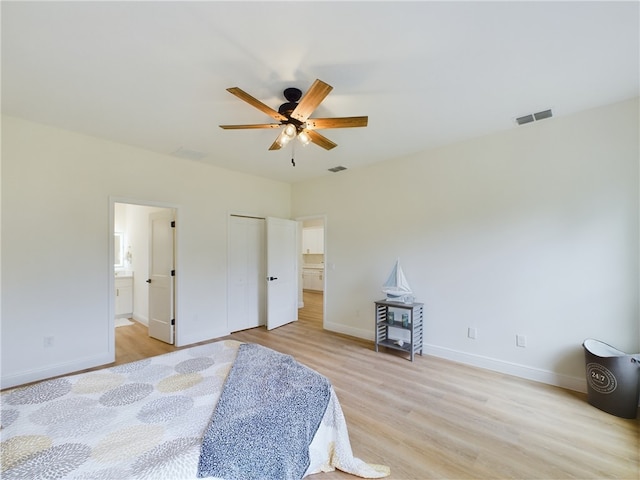 bedroom with ceiling fan, light hardwood / wood-style floors, a closet, and ensuite bath