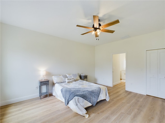 bedroom featuring ensuite bath, ceiling fan, and light wood-type flooring