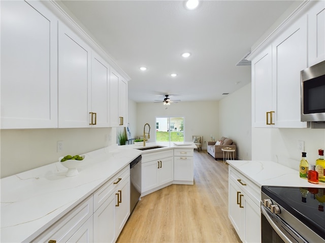 kitchen featuring light stone countertops, white cabinetry, sink, ceiling fan, and stainless steel appliances