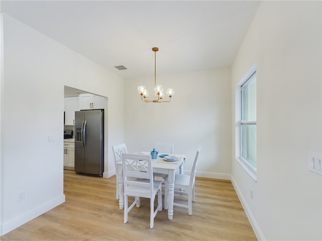 dining room featuring light hardwood / wood-style flooring and a notable chandelier