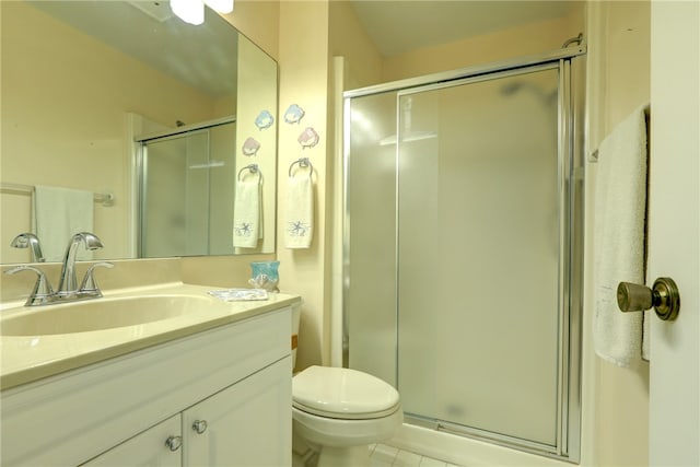 bathroom with tile patterned floors, toilet, vanity, and walk in shower