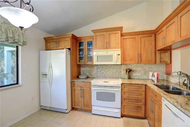 kitchen with light stone countertops, tasteful backsplash, white appliances, vaulted ceiling, and sink