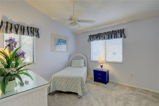 bedroom featuring light colored carpet, multiple windows, lofted ceiling, and ceiling fan