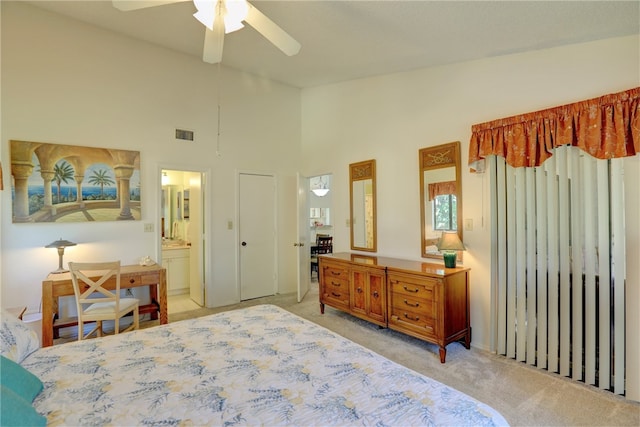 bedroom with ensuite bathroom, ceiling fan, light colored carpet, and high vaulted ceiling