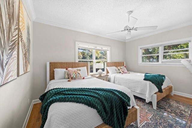 449 S Garcon Point Rd Fl, Milton, FL 32583 - bedroom with multiple windows, wood finished floors, crown molding, ceiling fan, and a textured ceiling
