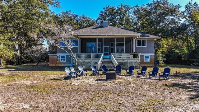 449 S Garcon Point Rd Fl, Milton, FL 32583 - rear view of house featuring a sunroom, an outdoor fire pit, stairs, a chimney, and a lawn