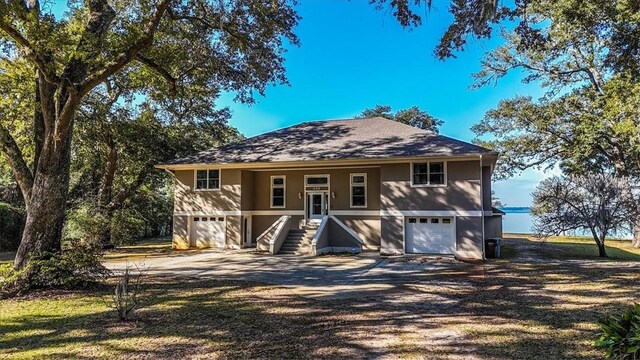 449 S Garcon Point Rd Fl, Milton, FL 32583 - view of front of property with dirt driveway, a garage, stairway, and stucco siding