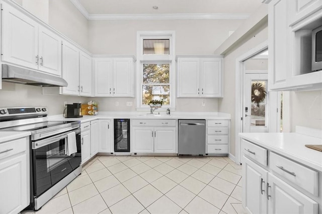 449 S Garcon Point Rd Fl, Milton, FL 32583 - kitchen with appliances with stainless steel finishes, under cabinet range hood, beverage cooler, light countertops, and white cabinetry
