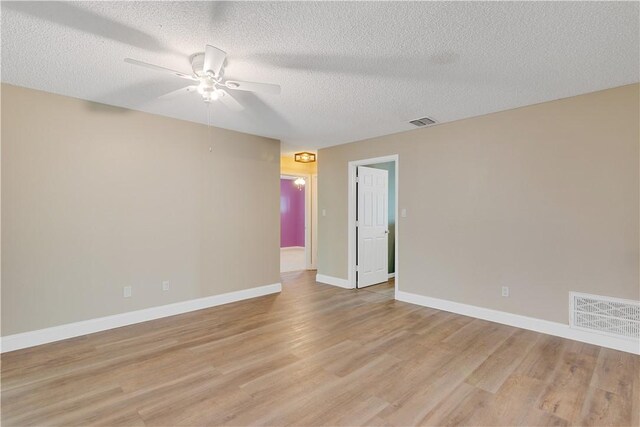 spare room featuring a textured ceiling, ceiling fan, and light hardwood / wood-style flooring