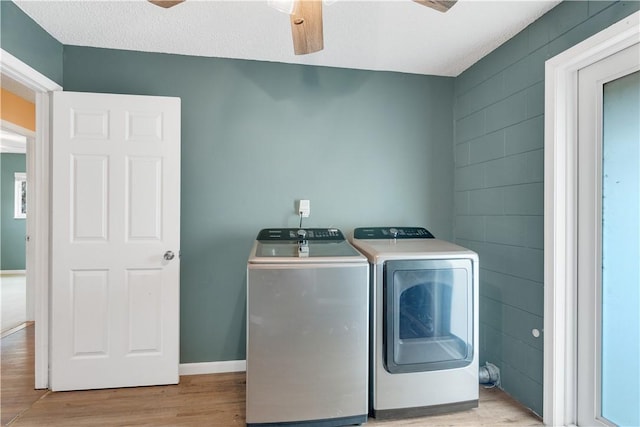 washroom featuring ceiling fan, light wood-type flooring, washing machine and dryer, and a textured ceiling