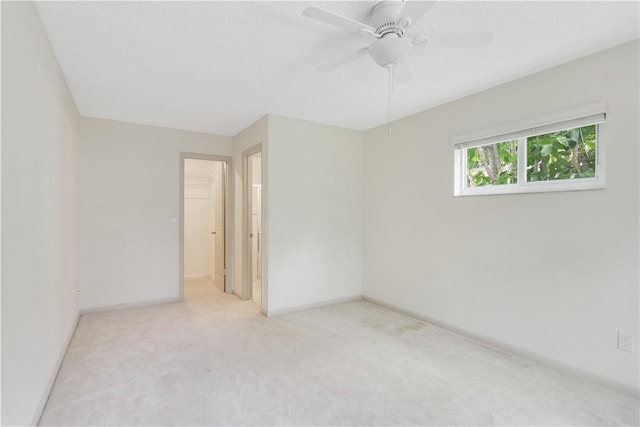 spare room with ceiling fan and light colored carpet