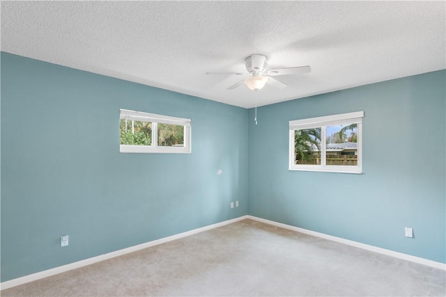 carpeted empty room featuring a textured ceiling and ceiling fan