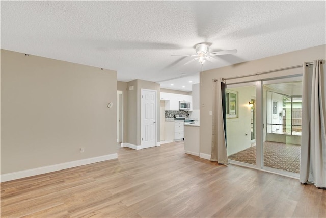 unfurnished living room featuring a textured ceiling, ceiling fan, and light hardwood / wood-style floors