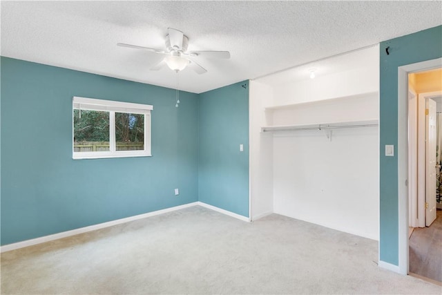 unfurnished bedroom with a closet, ceiling fan, a textured ceiling, and light colored carpet