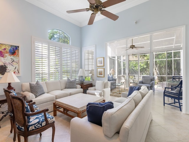 tiled living room featuring a wealth of natural light, ceiling fan, a towering ceiling, and ornamental molding