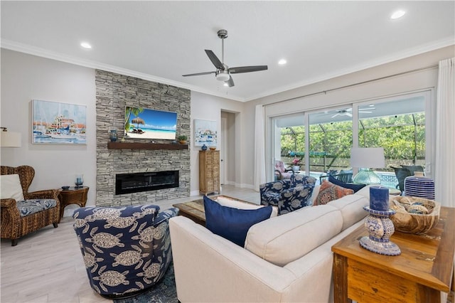 living room featuring ceiling fan, light wood-type flooring, ornamental molding, recessed lighting, and a fireplace