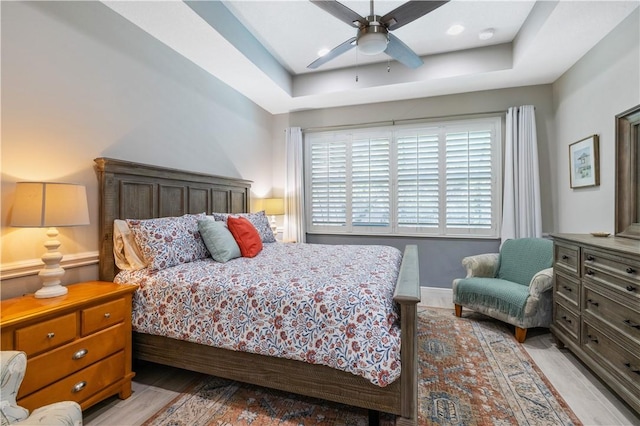 bedroom featuring a ceiling fan and a tray ceiling