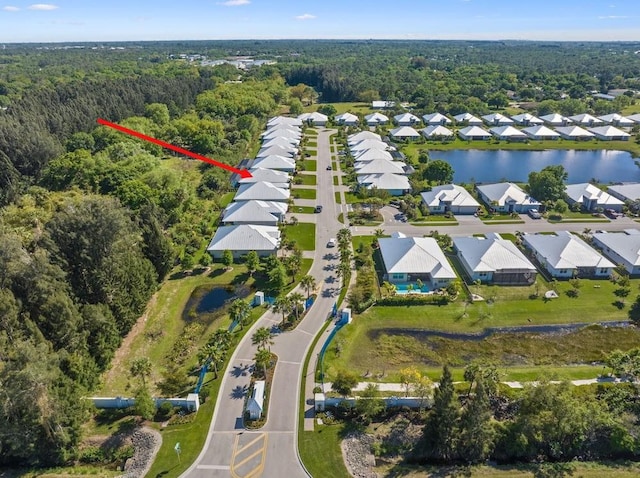 birds eye view of property with a residential view, a view of trees, and a water view