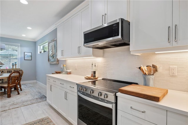 kitchen featuring white cabinetry, crown molding, backsplash, and appliances with stainless steel finishes