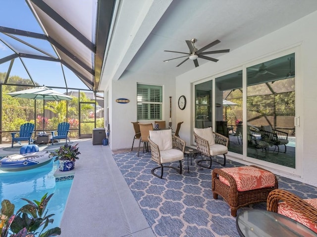 view of patio featuring a lanai, an outdoor pool, and a ceiling fan