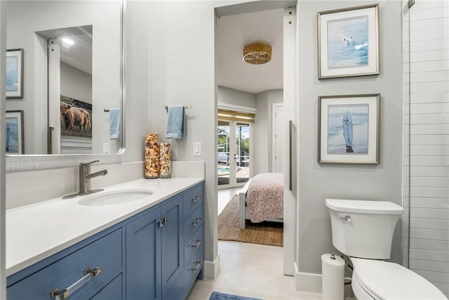 ensuite bathroom with vanity, toilet, french doors, and connected bathroom