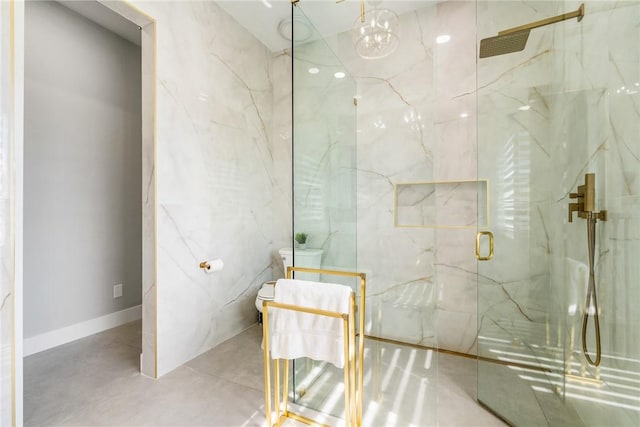 bathroom featuring a marble finish shower and toilet