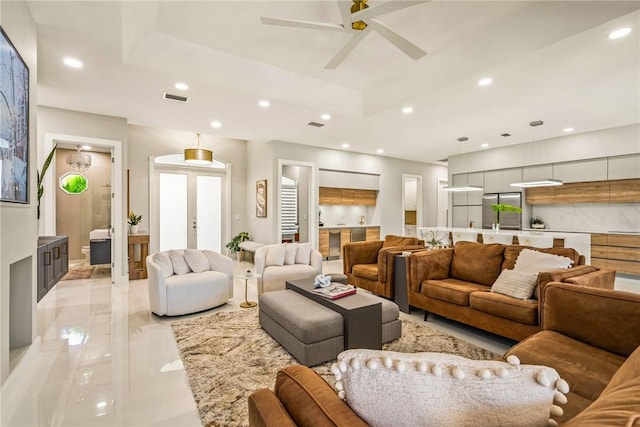 living room featuring a ceiling fan, visible vents, a tray ceiling, recessed lighting, and french doors