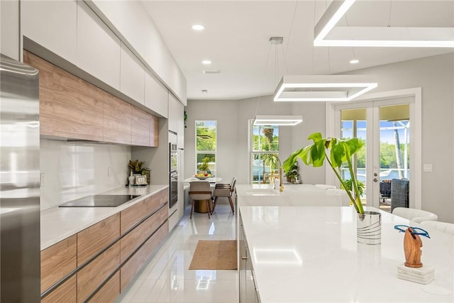 kitchen featuring recessed lighting, stainless steel appliances, light countertops, french doors, and modern cabinets