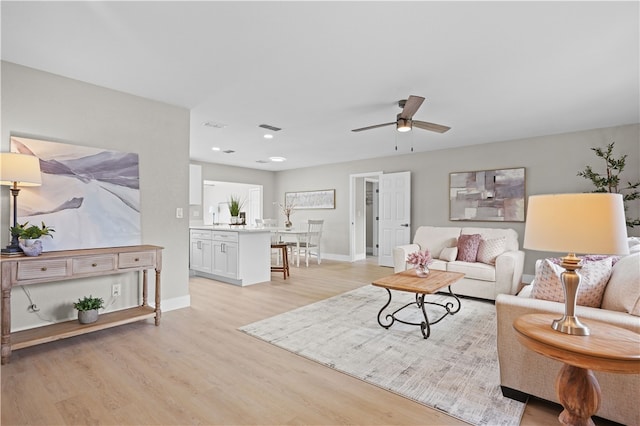 living area featuring recessed lighting, visible vents, baseboards, a ceiling fan, and light wood-style floors