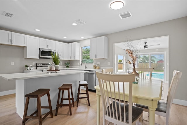 kitchen featuring appliances with stainless steel finishes, light countertops, visible vents, and white cabinetry