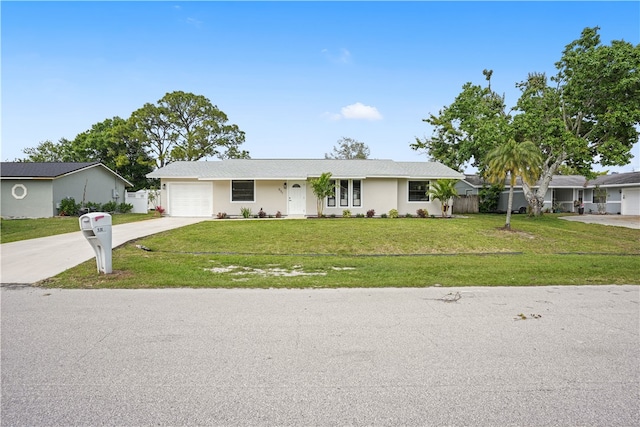 single story home featuring an attached garage, driveway, a front yard, and fence