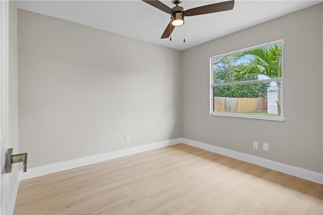 unfurnished room featuring wood finished floors, a ceiling fan, and baseboards