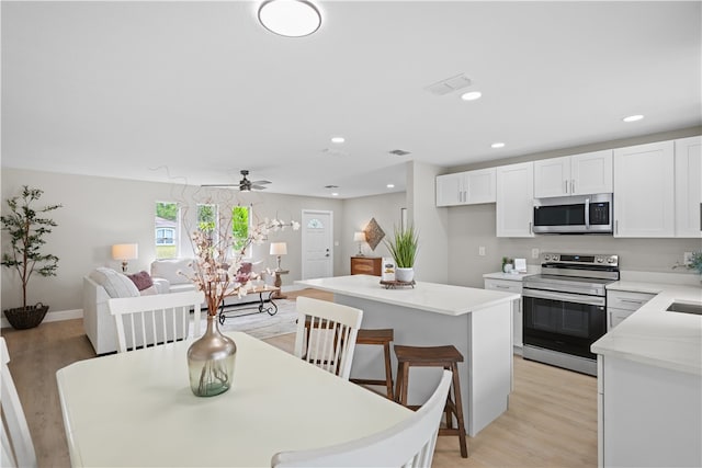 dining room with light wood-style floors, visible vents, a ceiling fan, and recessed lighting