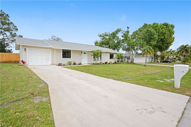 ranch-style house featuring stucco siding, an attached garage, fence, driveway, and a front lawn