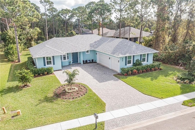 ranch-style house featuring a garage and a front lawn